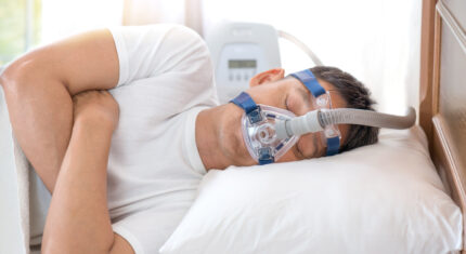 Mężczyzna śpiący z aparatem CPAP - bezdech-senny.info.pl