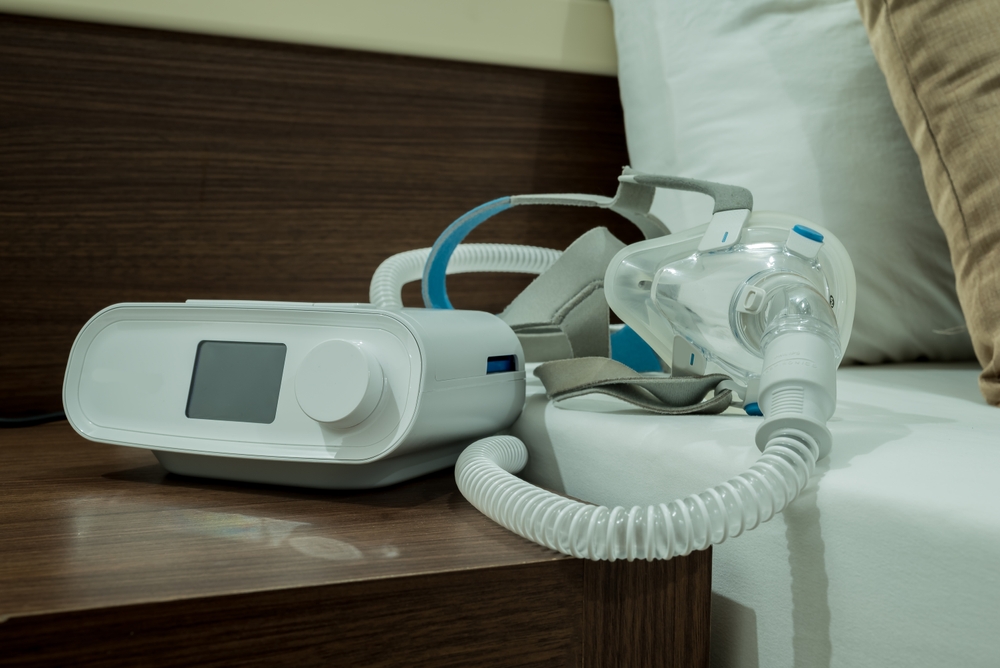 Aparat CPAP i maska leżące na stoliku nocnym – bezdech-senny.info.pl